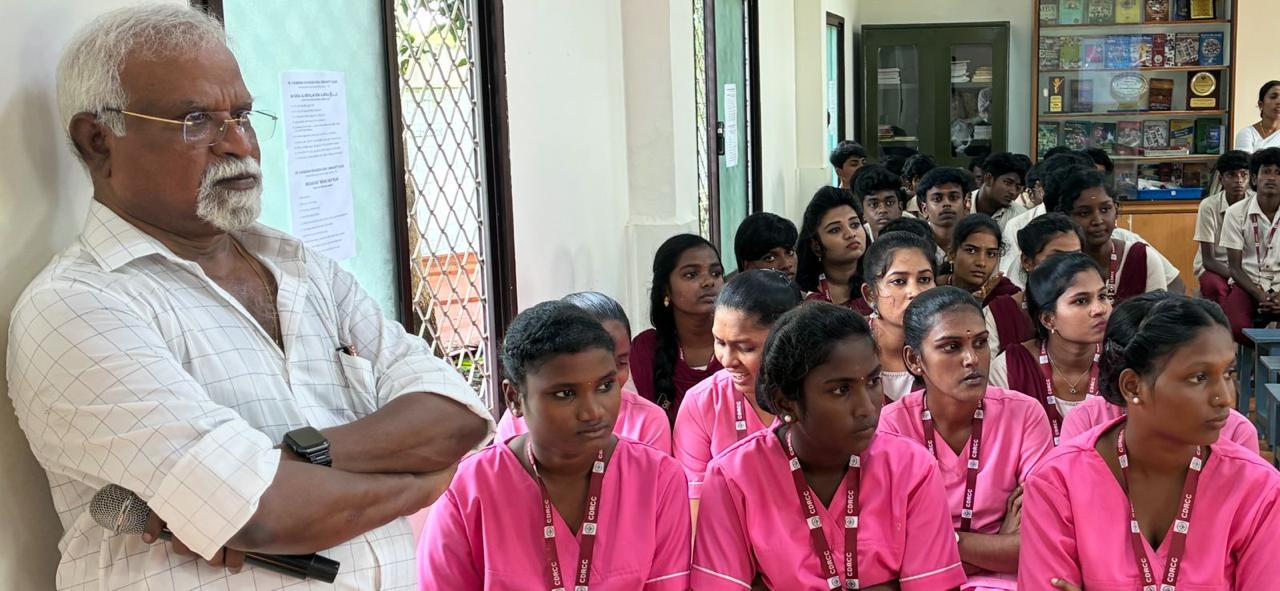 A speaker addressing students at the Dr. Chandran Devanesen Community College