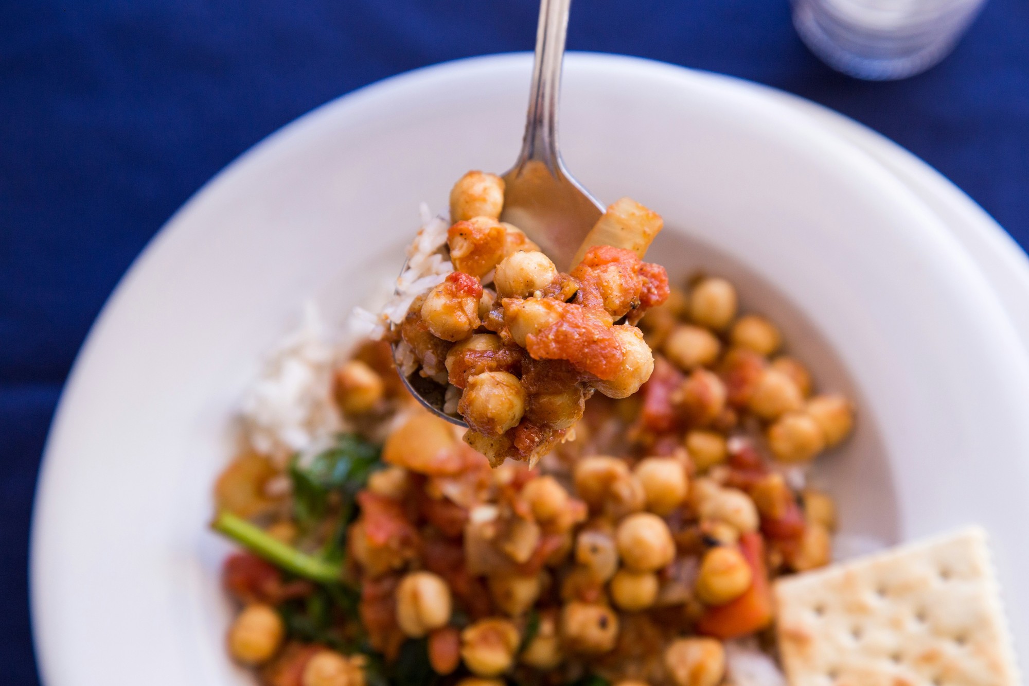A bowl of oil-free chana masala, garnished with fresh coriander, ginger and tomato